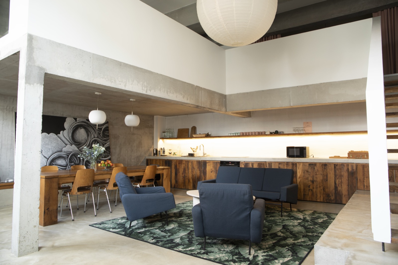 Salon avec fauteuils bleus et cuisine